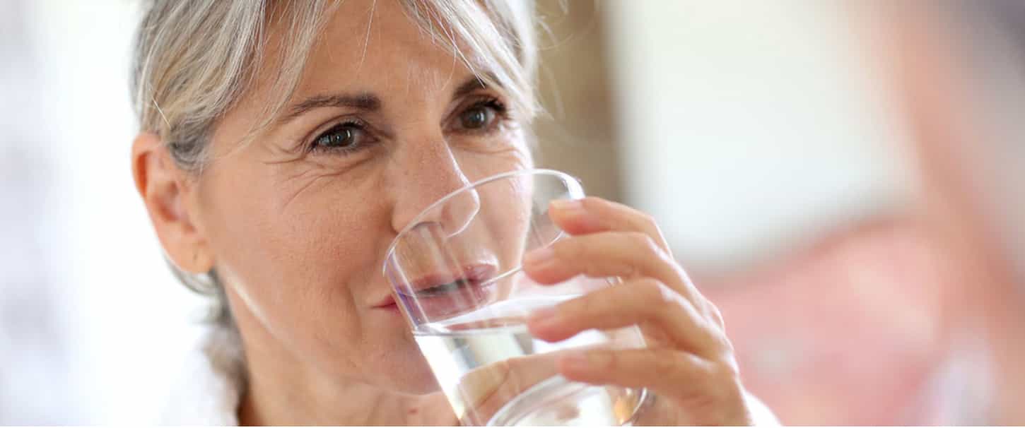 Donna che beve un bicchiere di acqua 