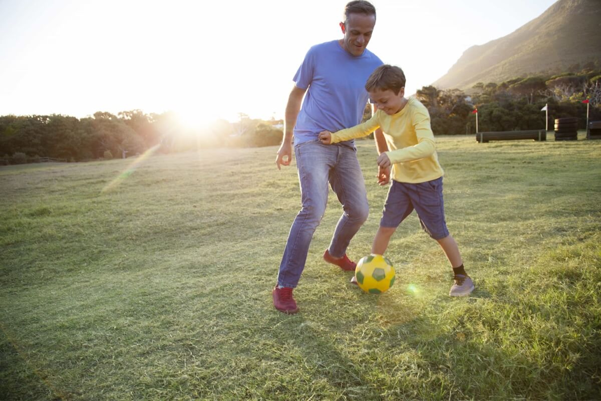 Papà e figlio giocano a calcio insieme. 