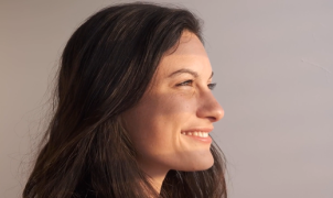 Donna che sorride guardando fuori dalla finestra 