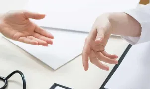 la mano di un dottore sta per prendere quella di un paziente, a dimostrazione del suo supporto 