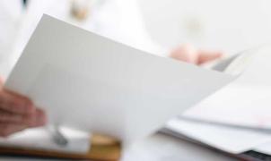 Mano di un un medico che analizza un referto posto in primo piano